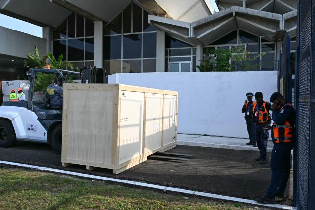 A crate containing the Djidji Ayokwe drum, also known as the talking drum, that was looted by French colonial troops from Ivory Coast in 1916, arrives during the latest repatriation of stolen artefacts at the Félix Houphouët-Boigny International Airport in Abidjan on March 13, 2026. The Djidji Ayokwe drum, more than three metres (10 feet) long and weighing 430 kilos (950 pounds) was used by the Ebrie tribe to transmit messages.
It is one of hundreds of objects France is sending back to Africa.
France has been flooded with restitution demands from former colonies such as Algeria, Mali and Benin.
Its national museums hold tens of thousands of artworks and other prized artefacts that were seized or purchased during the colonial era. (Photo by Issouf SANOGO / AFP)