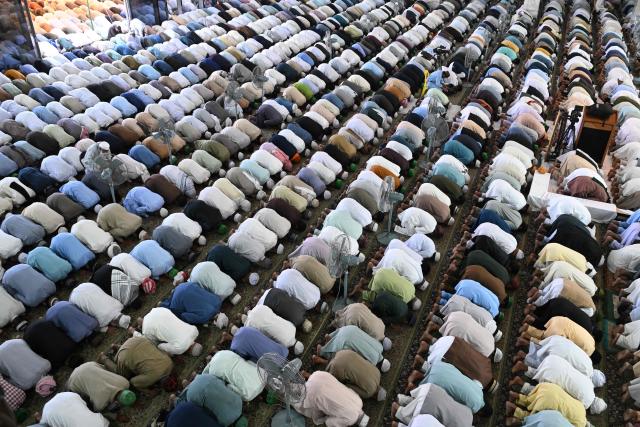 Muslim devotees offer their last Friday prayers of the Islamic holy fasting month of Ramadan, at Data Darbar mosque in Lahore on March 13, 2026. (Photo by Arif ALI / AFP)