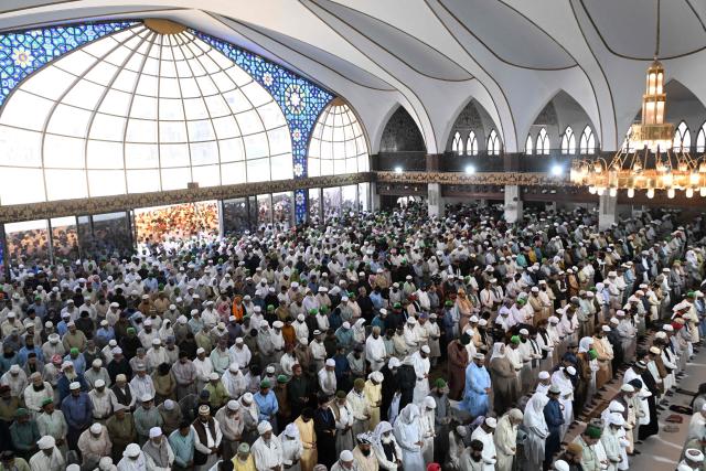 Muslim devotees offer their last Friday prayers of the Islamic holy fasting month of Ramadan, at Data Darbar mosque in Lahore on March 13, 2026. (Photo by Arif ALI / AFP)