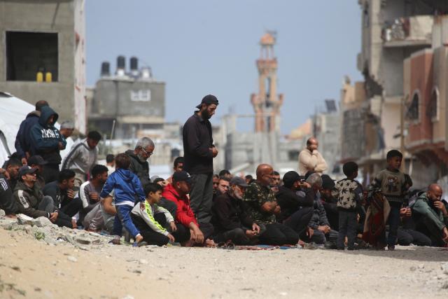 Palestinian Muslims pray during the last Friday noon prayer of the Muslim holy fasting month of Ramadan, outside the Al-Talbani Mosque, destroyed by the Israeli military in Khan Yunis, in the southern Gaza Strip on  March 13, 2026. (Photo by Bashar Taleb / AFP)