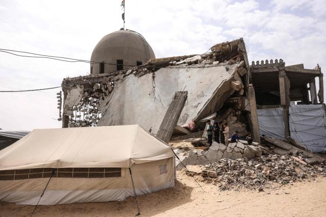 Palestinian boys pray during the last Friday noon prayer of the Muslim holy fasting month of Ramadan, outside the Al-Talbani Mosque, destroyed by the Israeli military in Khan Yunis, in the southern Gaza Strip on  March 13, 2026. (Photo by Bashar Taleb / AFP)