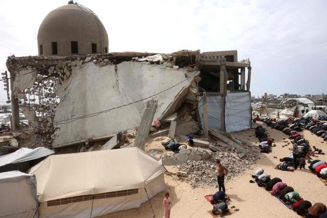 Palestinian Muslims pray during the last Friday noon prayer of the Muslim holy fasting month of Ramadan, outside the Al-Talbani Mosque, destroyed by the Israeli military in Khan Yunis, in the southern Gaza Strip on  March 13, 2026. (Photo by Bashar Taleb / AFP)