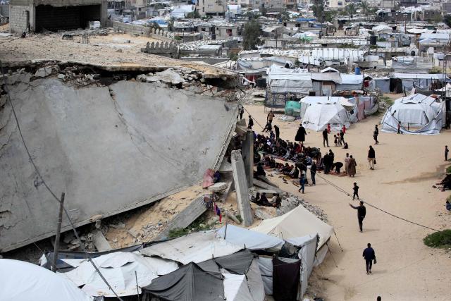 Palestinian Muslims pray during the last Friday noon prayer of the Muslim holy fasting month of Ramadan, outside the Al-Talbani Mosque, destroyed by the Israeli military in Khan Yunis, in the southern Gaza Strip on  March 13, 2026. (Photo by Bashar Taleb / AFP)