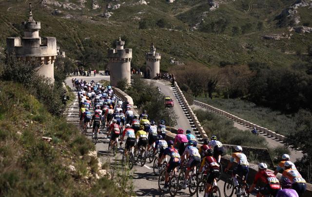 The pack rides past the stations of the Cross, a road leading to the Frigolet Abbey in Tarascon during the 6th stage of the Paris-Nice cycling race, 179.3 km between Barbentane and Apt, on March 13, 2026. (Photo by Anne-Christine POUJOULAT / AFP)