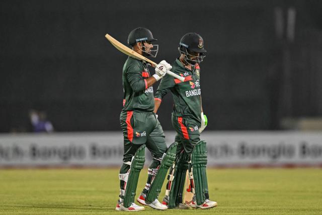 Bangladesh's Litton Das (L) and Towhid Hridoy walk off the field as play gets delayed due to bad weather conditions during the second one-day international (ODI) cricket match between Bangladesh and Pakistan at Sher-e-Bangla National Stadium in Mirpur on March 13, 2026. (Photo by Munir UZ ZAMAN / AFP)