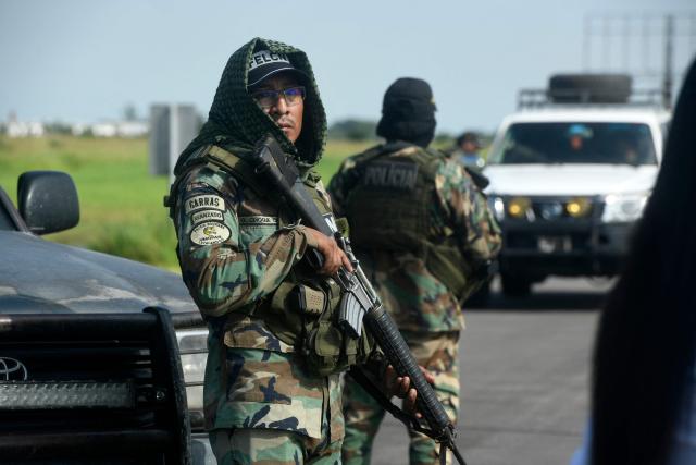 Police officers stand guard at the Viru Viru airport in Santa Cruz, Bolivia, where Uruguayan alleged drug trafficker Sebastian Marset is reportedly being transferred after an operation carried out by agents from the Special Counter-Narcotics Force and the Tactical Police Operations Unit (UTOP), on March 13, 2026. A top Latin American narco trafficker, Sebastian Enrique Marset Cabrera, who was wanted in several countries, including the United States, was arrested Friday in Bolivia, a government source told AFP. (Photo by Rodrigo URZAGASTI / AFP)
