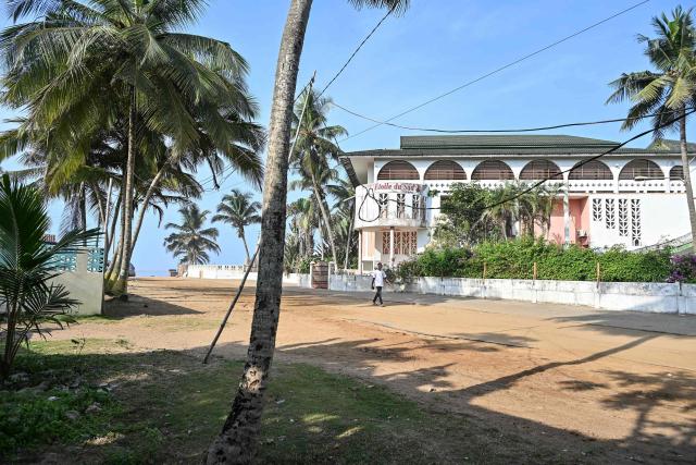 A young man walks past the closed Etoile du Sud hotel, where people were killed during a jihadist attack a decade ago, at a beach in Grand-Bassam on March 13, 2026. Ivory Coast on March 13, 2026 commemorated the 19 victims of a jihadist attack on a popular beach resort a decade ago.
Three attackers wielding assault rifles stormed the beach at Grand-Bassam, popular with foreigners and 40 kilometres (25 miles) east of the main city of Abidjan, on March 13, 2016 before attacking restaurants. 
The 45-minute bloodbath ended when Ivorian security forces shot the attackers dead. (Photo by Sia KAMBOU / AFP)