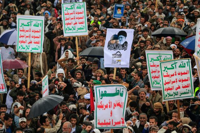 Supporters of Yemen's Houthi rebels hold a placard bearing a portratit of Irans slain supreme leader Ayatollah Ali Khamenei during the Al-Quds (Jerusalem) Day rally, a commemoration in support of the Palestinian people on the last Friday of the Islamic holy month of Ramadan, in Sanaa on March 13, 2026. Yemen's Houthi rebels on March 9, welcomed Iran's ruling clerics appointing their slain leader's son as the country's new supreme leader, calling it a major blow for the Islamic republic's enemies as it fights a war with the United States and Israel. (Photo by Mohammed HUWAIS / AFP)