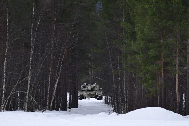 A tank is seen in a forest near the Bardufoss Airbase in Norway on March 13, 2026, prior to the start of a demonstration, as part of the Cold Response military exercise. (Photo by John MACDOUGALL / AFP)