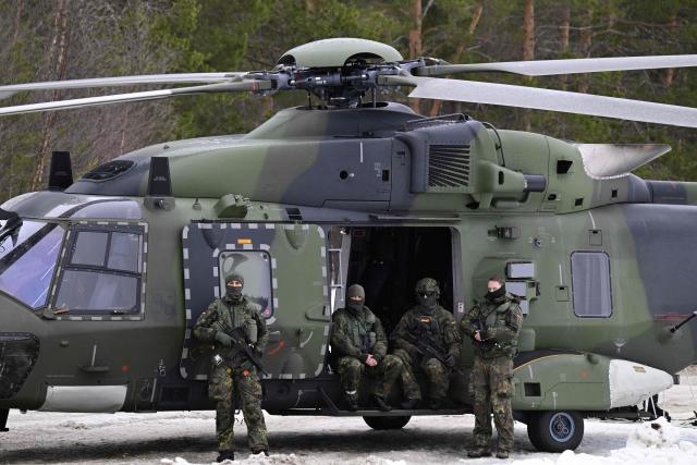 German Bundeswehr soldiers wait next to an NH90 helicopter near the Bardufoss Airbase in Norway on March 13, 2026. (Photo by John MACDOUGALL / AFP)