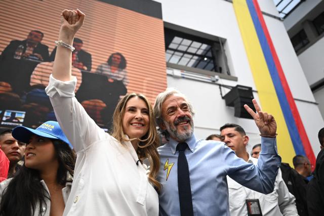 Colombia's presidential candidate for the conservative Democratic Centre party, Paloma Valencia (R), raises her clenched fist as her running mate, Juan Daniel Oviedo (R) flashes the V sign, during an event after registering their candidacy, in Bogota, on March 12, 2026. Colombia will hold presidential elections on May 31, 2026. (Photo by RAUL ARBOLEDA / AFP)