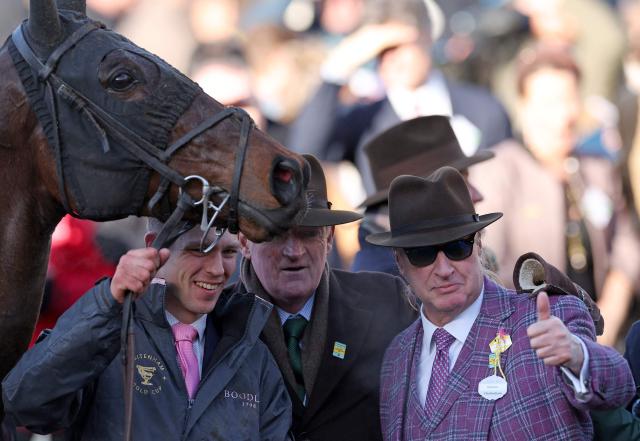Gaelic Warrior racehorse owner Rich Ricci (R) celebrates with trainer Willie Mullins after jockey Paul Townend rode to win the Gold Cup chase horse race on the fourth day of the Cheltenham Festival at Cheltenham Racecourse, in Cheltenham, western England on March 13, 2026. (Photo by Adrian Dennis / AFP)