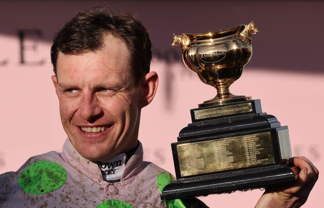 Jockey Paul Townend celebrates with the Gold Cup trophy after riding Gaelic Warrior to win the Gold Cup chase horse race on the fourth day of the Cheltenham Festival at Cheltenham Racecourse, in Cheltenham, western England on March 13, 2026. (Photo by Adrian Dennis / AFP)