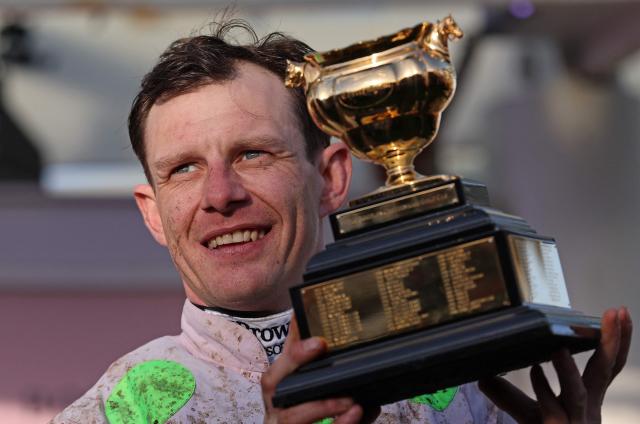 Jockey Paul Townend celebrates with the Gold Cup trophy after riding Gaelic Warrior to win the Gold Cup chase horse race on the fourth day of the Cheltenham Festival at Cheltenham Racecourse, in Cheltenham, western England on March 13, 2026. (Photo by Adrian Dennis / AFP)