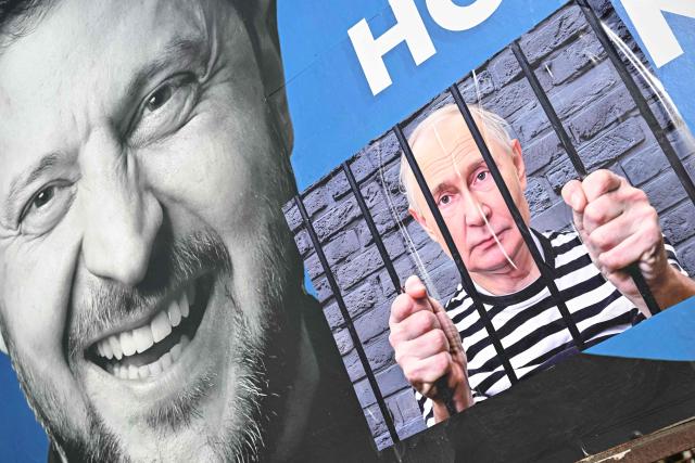 A “corrected” government billboard showing Ukrainian President Volodymyr Zelensky and a composite image of Russian President Vladimir Putin behind bars, is seen in Pecs, Hungary on March 13, 2026. The word “not” was crossed out, and a photo of Vladimir Putin with a sign saying “the state campaign billboard is election fraud” was added. (Photo by Attila KISBENEDEK / AFP)