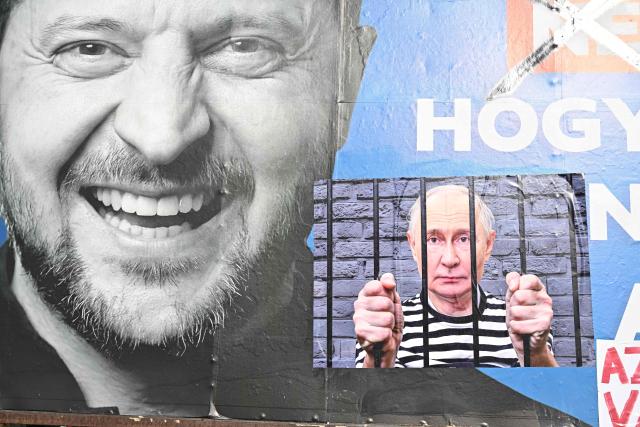 A “corrected” government billboard showing Ukrainian President Volodymyr Zelensky and a composite image of Russian President Vladimir Putin behind bars, is seen in Pecs, Hungary on March 13, 2026. The word “not” was crossed out, and a photo of Vladimir Putin with a sign saying “the state campaign billboard is election fraud” was added. (Photo by Attila KISBENEDEK / AFP)