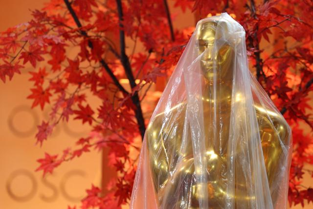 A decorative replica Oscar statue covered in protective plastic sheeting is seen as preparations are made on the red carpet arrivals area ahead of the 98th Annual Academy Awards in Hollywood, California, on March 13, 2026. (Photo by ANGELA WEISS / AFP)