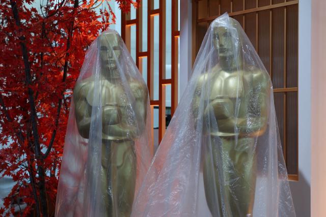Decorative replica Oscar statues covered in protective plastic sheeting are seen as preparations are made on the red carpet arrivals area ahead of the 98th Annual Academy Awards in Hollywood, California, on March 13, 2026. (Photo by ANGELA WEISS / AFP)