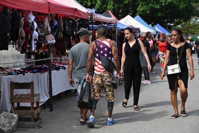 A man wearing a T-shirt with the United States flag walks down a street in Havana on March 13, 2026. Cuba's President Miguel Diaz-Canel confirmed on March 13, 2026 that “Cuban officials have recently held talks” with representatives of the United States, amid heightened tensions between Washington and Havana. (Photo by YAMIL LAGE / AFP)