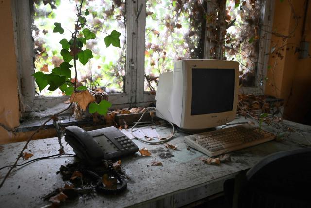 This photograph shows a desk in the offices of an abandonned steel plant in Charleroi, southern Belgium, on February 9, 2026. Once a major industrial city of the coal industry, Charleroi still bears the marks of a working-class past now lying fallow. As they venture through its abandoned factories, urban explorers (urbex) end up telling the story of a system as much as of a pastime: that of a capitalism which pours investment into a place, exploits it, then withdraws, leaving behind nothing but ruins to explore. (Photo by Nicolas TUCAT / AFP)
