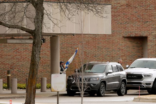 A person carries a flag of Israel from Temple Israel synagogue in West Bloomfield, Michigan, on March 13, 2026, after a person drove a vehicle into the synagogue a day earlier. Ayman Mohamad Ghazali, 41, was killed by security guards on March 12, after he rammed his pickup truck into the Temple Israel synagogue on the outskirts of Detroit causing a blaze and triggering a huge police response. US media reported he had recently lost family members in an Israeli strike in Lebanon, as part of the ongoing Middle East war. (Photo by JEFF KOWALSKY / AFP)