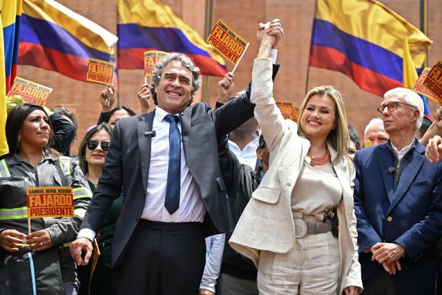 Colombia's presidential candidate for the Dignidad y Compromiso party, Sergio Fajardo, and his vice-presidential candidate Edna Bonilla, raise their hands after registering their candidacies in Bogota, on March 13, 2026. Colombia will hold presidential elections on May 31, 2026. (Photo by RAUL ARBOLEDA / AFP)