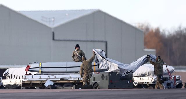 USAF military personnel work on AGM-158 joint air-to-surface standoff cruise missiles, near a US Air Force B-1 Lancer bomber jet,on the tarmac after it landed at RAF Fairford in south-west England on March 13, 2026. Fairford is one of two bases, along with the Diego Garcia facility in the Indian Ocean, that the UK has given the US permission to use for "specific defensive operations into Iran" to destroy Iranian missiles at source, the British defence minister said in a statement. (Photo by Henry NICHOLLS / AFP)