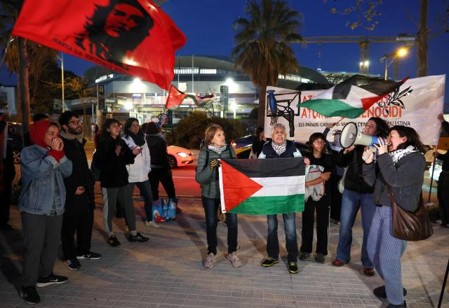 Protesters hold Paslestine flags and shout slogans during a demonstration against the participation of Israeli basketball team Hapoel IBI Tel-Aviv in the Euroleague, ahead of their match against FC Barcelona at Palau Blaugrana arena in Barcelona on March 13, 2026. (Photo by Lluis GENE / AFP)