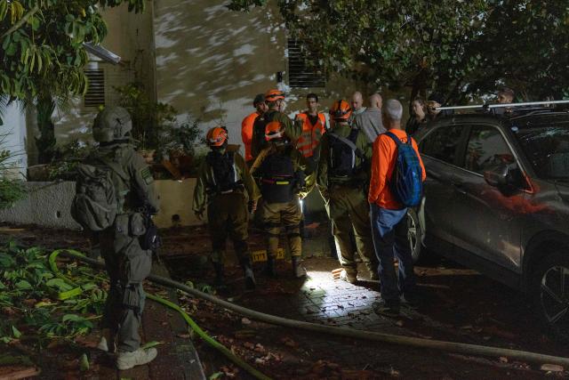 First responders inspect a house that was reportedly hit by a projectile in Shoham  in central Israel, near Tel Aviv, on March 13, 2026. Smoke could be seen rising from two locations around Israel's commercial hub Tel Aviv on March 13, AFP journalists said, after blasts were heard following a warning that missiles were fired from Iran. (Photo by Ilia YEFIMOVICH / AFP) / 