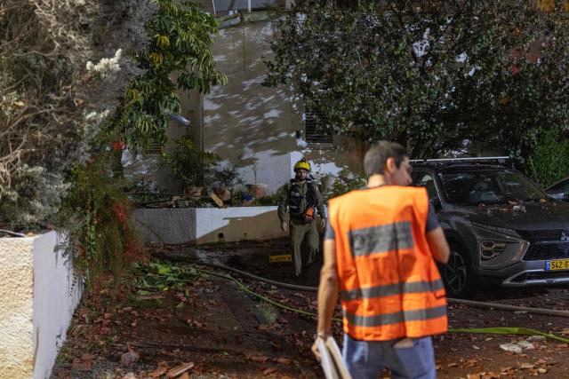First responders inspect a house that was reportedly hit by a projectile in Shoham  in central Israel, near Tel Aviv, on March 13, 2026. Smoke could be seen rising from two locations around Israel's commercial hub Tel Aviv on March 13, AFP journalists said, after blasts were heard following a warning that missiles were fired from Iran. (Photo by Ilia YEFIMOVICH / AFP) / 