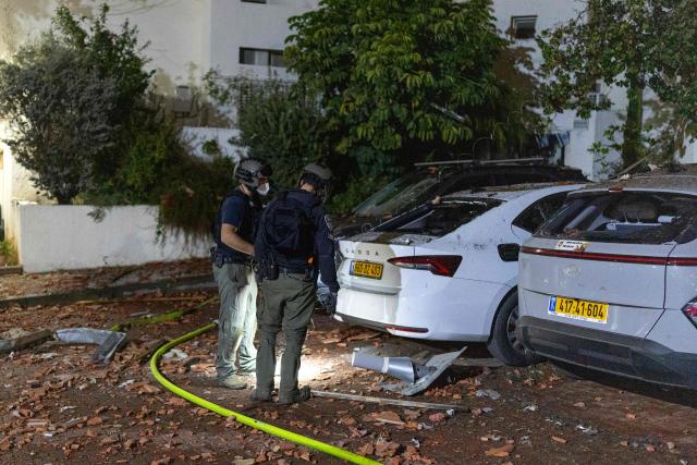 Irsraeli police inspect the damage at a house that was reportedly hit by a projectile in Shoham  in central Israel, near Tel Aviv, on March 13, 2026. Smoke could be seen rising from two locations around Israel's commercial hub Tel Aviv on March 13, AFP journalists said, after blasts were heard following a warning that missiles were fired from Iran. (Photo by Ilia YEFIMOVICH / AFP) / 