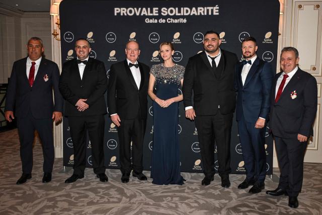 Prince Albert II of Monaco (C-L) and Princess Charlene of Monaco (C-R) pose with French-Algerian rugby player and president of Provale Malik Hamadache (3rdR), French former rugby player and General Manager of Provale Mathieu Giudicelli (2ndL), Princess of Monaco's brother Gareth Wittstock (2ndR), Vice President at the Monegasque Rugby Federation Thierry Danthez (R) and the technical director of the Monegasque rugby federation Nicolas Bonnet (L), during a photocall as part of the Provale Solidarite charity gala at the Hotel Georges V in Paris on March 13, 2026. (Photo by Bertrand GUAY / AFP) / NO TABLOIDS WEB & PRINT, NO DAILY MAIL, NO DAILY MAIL GROUP, NO VOICI, NO CLOSER