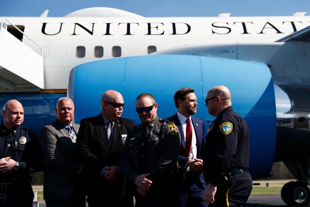 US Vice President JD Vance (2R) speaks to members of law enforcement as he prepares to board Air Force Two as he returns to Washington, DC at Rocky Mount-Wilson Regional Airport on March 13, 2026 in Elm City, North Carolina. Vance traveled to North Carolina to deliver remarks on the Trump administration's economic agenda. (Photo by Kent Nishimura / POOL / AFP)