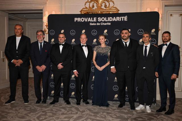 Prince Albert II of Monaco (C-L) and Princess Charlene of Monaco (C-R) pose with French-Algerian rugby player and president of Provale Malik Hamadache (3rdR), French former rugby player and General Manager of Provale Mathieu Giudicelli (3rdL), President of the French National Rugby League LNR (Ligue Nationale de Rugby) Yann Roubert (2ndR), Princess of Monaco's brother Gareth Wittstock (R), French former rugby player Olivier Roumat (L) and Vice-President of the French Rugby Federation Jean Marc Lhermet (2ndL),  during a photocall as part of the Provale Solidarite charity gala at the Hotel Georges V in Paris on March 13, 2026. (Photo by Bertrand GUAY / AFP) / NO TABLOIDS WEB & PRINT, NO DAILY MAIL, NO DAILY MAIL GROUP, NO VOICI, NO CLOSER