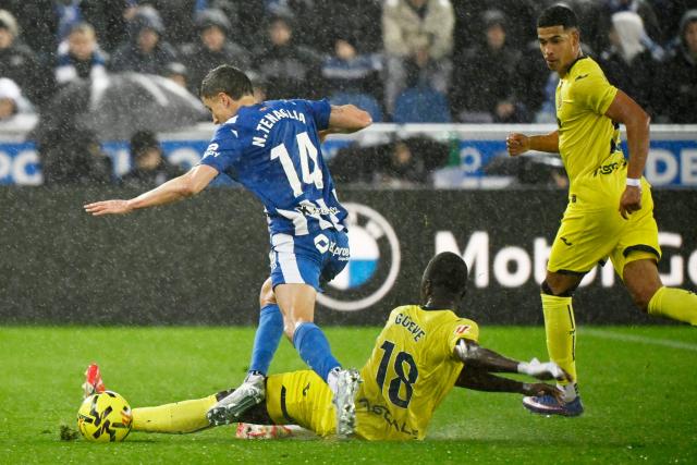 Villarreal's Senegalese midfielder #18 Pape Gueye tackles Alaves' Argentine defender #14 Nahuel Tenaglia during the Spanish League football match between Deportivo Alaves and Villarreal CF at Mendizorroza Stadium in Vitoria on March 13, 2026. (Photo by ANDER GILLENEA / AFP)