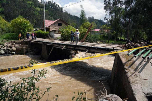 Locals repair a bridge after the Yanuncay River swelled in the Barabon area of Cuenca, Ecuador, on March 13, 2026. Ecuador declared a 60-day national emergency to confront an intense rainy season that has left 11 people dead and thousands affected since January, the government disaster management agency said on March 13. (Photo by Fernando Machado / AFP)