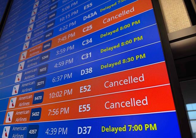 Cancelled and delayed flights are seen on a screen inside a terminal during a ground stop at Ronald Reagan Washington National Airport in Arlington, Virginia, on March 13, 2026. Ground stops are in effect at three major DC-area airports due to a "strong odor coming from the Potomac TRACON" (Terminal Radar Approach Control) facility in Warranton, Virginia, according to a post on X by US Secretary of Transportation Sean Duffy. (Photo by Drew ANGERER / AFP)