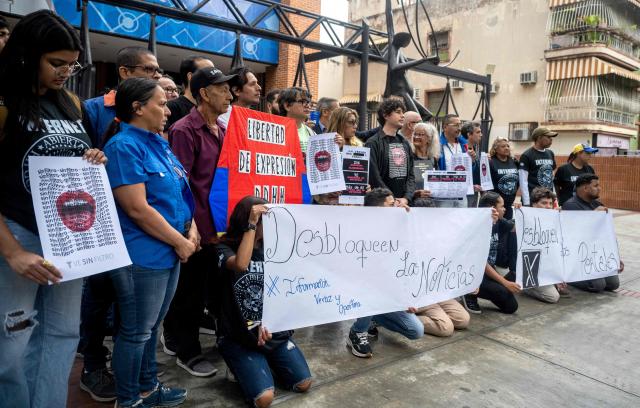 Human rights activists and members of the National Journalists Association of Venezuela take part in a demonstration to demand unblocking restricted websites in front of the National Commission of Telecommunications (Conatel) headquarters in Caracas on March 13, 2026. Chanting "freedom of expression for the internet and television," human rights activists called on Venezuela's interim government to unblock some 200 restricted websites on March 13, 2026. (Photo by Maryorin Mendez / AFP)