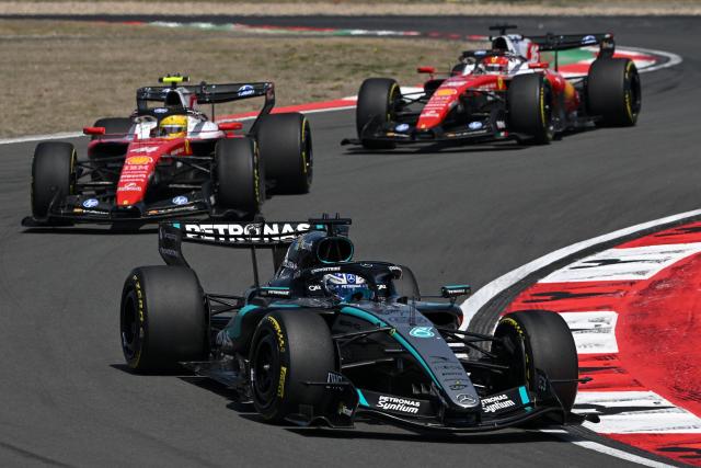 Mercedes' British driver George Russell (R) drives in front of Ferrari's British driver Lewis Hamilton (L) and Ferrari's Monegasque driver Charles Leclerc (top) during the sprint race ahead of the Formula One Chinese Grand Prix at the Shanghai International Circuit in Shanghai on March 14, 2026. (Photo by JADE GAO / AFP)