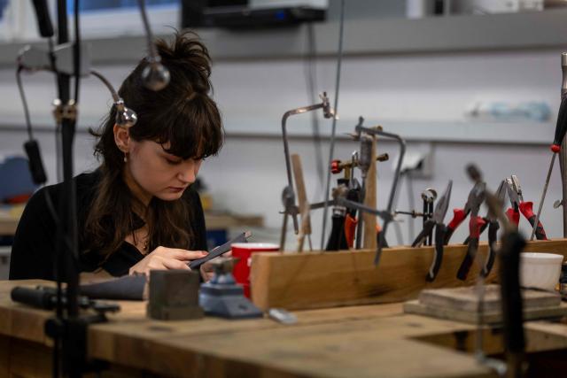 A student works on a piece of jewellery she has designed at workshop of Experimental Design Studio on Academy of Fine Arts in Gdansk, Poland on March 10, 2026. Long coveted for its golden color, scientific value and alleged healing properties, amber is now coming into the hand of young Polish jewelers, bringing the ancient resin into modern times. Together with drills, sanders, blasters, and power saws which look like they belong to a bygone era, virtual reality stations are used to combine earlier tools with state-of-the-art technology at the Academy of Fine Arts in Gdansk, a city on Poland's Baltic Coast known as amber's global capital. (Photo by Wojtek RADWANSKI / AFP)