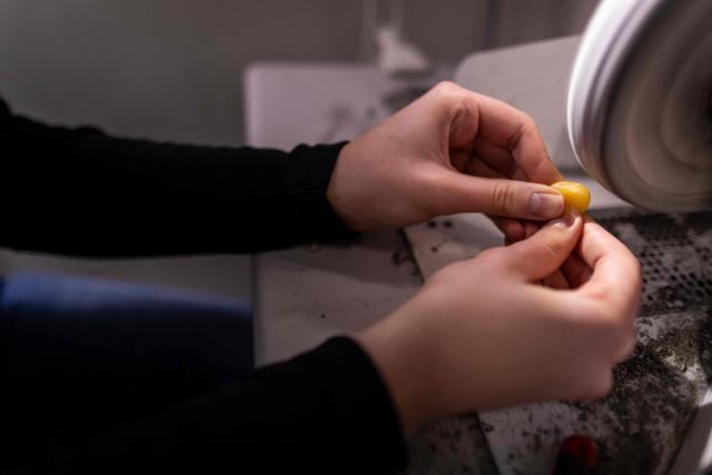 A student polish the piece of natural Baltic amber at workshop of Experimental Design Studio on Academy of Fine Arts in Gdansk, Poland on March 10, 2026. Long coveted for its golden color, scientific value, and alleged healing properties, amber is now coming into the hand of young Polish jewelers, bringing the ancient resin into modern times. Together with drills, sanders, blasters, and power saws which look like they belong to a bygone era, virtual reality stations are used to combine earlier tools with state-of-the-art technology at the Academy of Fine Arts in Gdansk, a city on Poland's Baltic Coast known as amber's global capital. (Photo by Wojtek RADWANSKI / AFP)