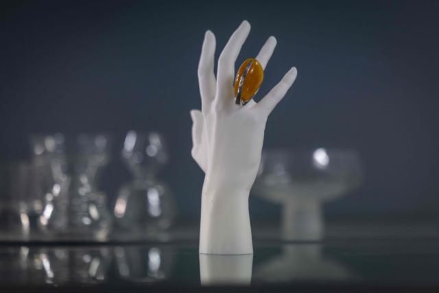 This picture presents piece of artistic jewellery made of natural Baltic amber, designed and created by student of Experimental Design Stuio on Academy of Fine Arts in Gdansk, Poland on March 10, 2026. Long coveted for its golden color, scientific value, and alleged healing properties, amber is now coming into the hand of young Polish jewelers, bringing the ancient resin into modern times. Together with drills, sanders, blasters, and power saws which look like they belong to a bygone era, virtual reality stations are used to combine earlier tools with state-of-the-art technology at the Academy of Fine Arts in Gdansk, a city on Poland's Baltic Coast known as amber's global capital. (Photo by Wojtek RADWANSKI / AFP)