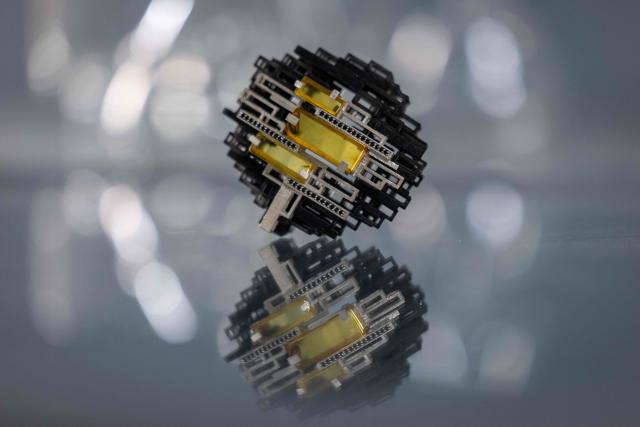 This picture presents piece of artistic jewellery made of natural Baltic amber, designed and created with use of 3d printing by student of Experimental Design Stuio on Academy of Fine Arts in Gdansk, Poland on March 10, 2026. Long coveted for its golden color, scientific value, and alleged healing properties, amber is now coming into the hand of young Polish jewelers, bringing the ancient resin into modern times. Together with drills, sanders, blasters, and power saws which look like they belong to a bygone era, virtual reality stations are used to combine earlier tools with state-of-the-art technology at the Academy of Fine Arts in Gdansk, a city on Poland's Baltic Coast known as amber's global capital. (Photo by Wojtek RADWANSKI / AFP)