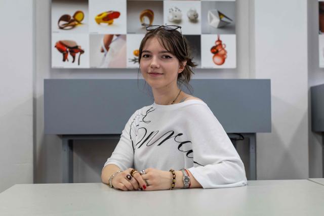 Paulina Smigiel - student of the Experimental Design Studio, poses for the picture at the Academy of Fine Arts in Gdansk, Poland on March 11, 2026. Long coveted for its golden color, scientific value and alleged healing properties, amber is now coming into the hand of young Polish jewelers, bringing the ancient resin into modern times. Together with drills, sanders, blasters, and power saws which look like they belong to a bygone era, virtual reality stations are used to combine earlier tools with state-of-the-art technology at the Academy of Fine Arts in Gdansk, a city on Poland's Baltic Coast known as amber's global capital. (Photo by Wojtek RADWANSKI / AFP)