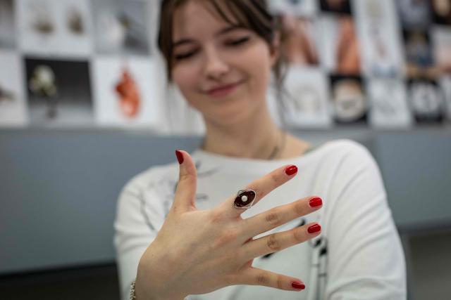 Paulina Smigiel - student of the Experimental Design Studio, present a ring she designed by herself with a piece of natural Baltic amber at the Academy of Fine Arts in Gdansk, Poland on March 11, 2026. Long coveted for its golden color, scientific value and alleged healing properties, amber is now coming into the hand of young Polish jewelers, bringing the ancient resin into modern times. Together with drills, sanders, blasters, and power saws which look like they belong to a bygone era, virtual reality stations are used to combine earlier tools with state-of-the-art technology at the Academy of Fine Arts in Gdansk, a city on Poland's Baltic Coast known as amber's global capital. (Photo by Wojtek RADWANSKI / AFP)