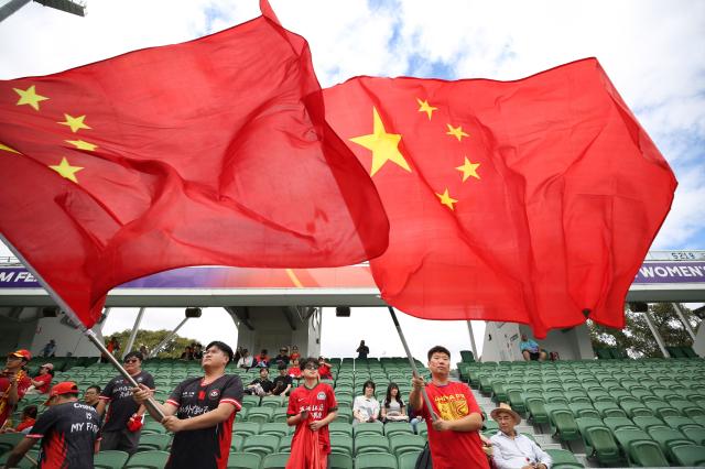 China fans wave the Chinese national flag before the AFC Women's Asian Cup Australia 2026 football match between China and Taiwan in Perth on March 14, 2026. (Photo by Antony DICKSON / AFP)
