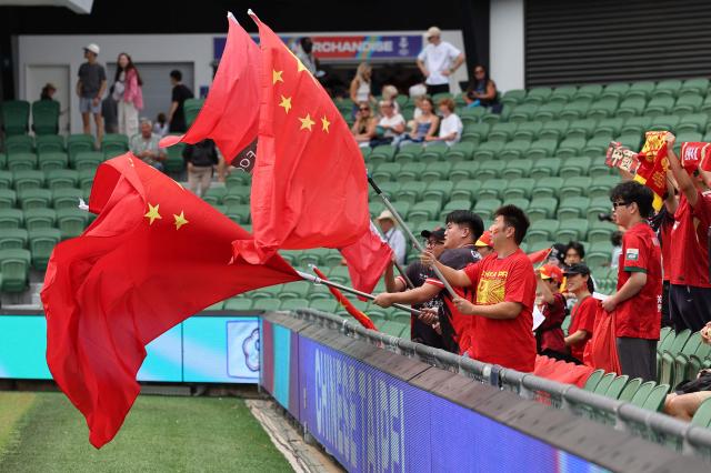 China fans wave the Chinese national flag before the AFC Women's Asian Cup Australia 2026 football match between China and Taiwan in Perth on March 14, 2026. (Photo by Antony DICKSON / AFP)