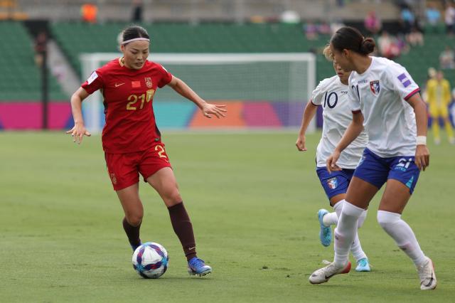 China’s Li Mengwen (L) and Taiwan’s Saki Matsunaga (C) fight for the ball during the AFC Women's Asian Cup Australia 2026 football match between China and Taiwan in Perth on March 14, 2026. (Photo by Antony DICKSON / AFP)