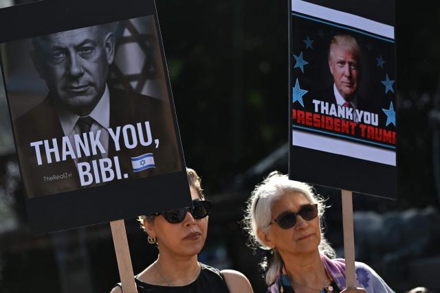 Members of the Iranian community hold placards, wave flags and chant slogans during a rally following US and Israeli attacks on Iran, in Sydney on March 14, 2026. (Photo by Saeed KHAN / AFP)