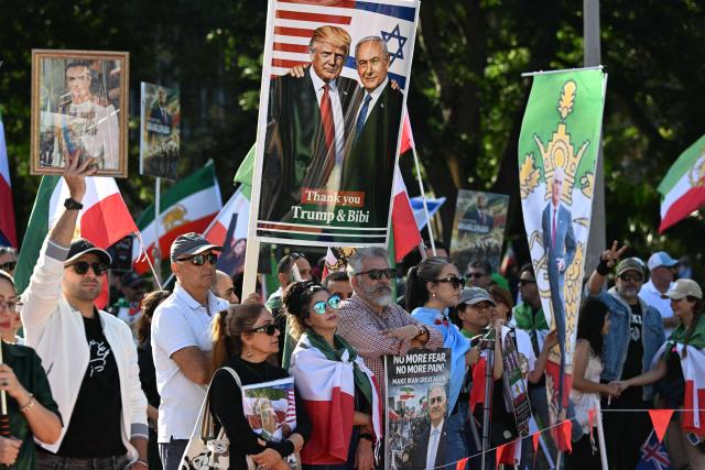 Members of the Iranian community hold placards, wave flags and chant slogans during a rally following US and Israeli attacks on Iran, in Sydney on March 14, 2026. (Photo by Saeed KHAN / AFP)